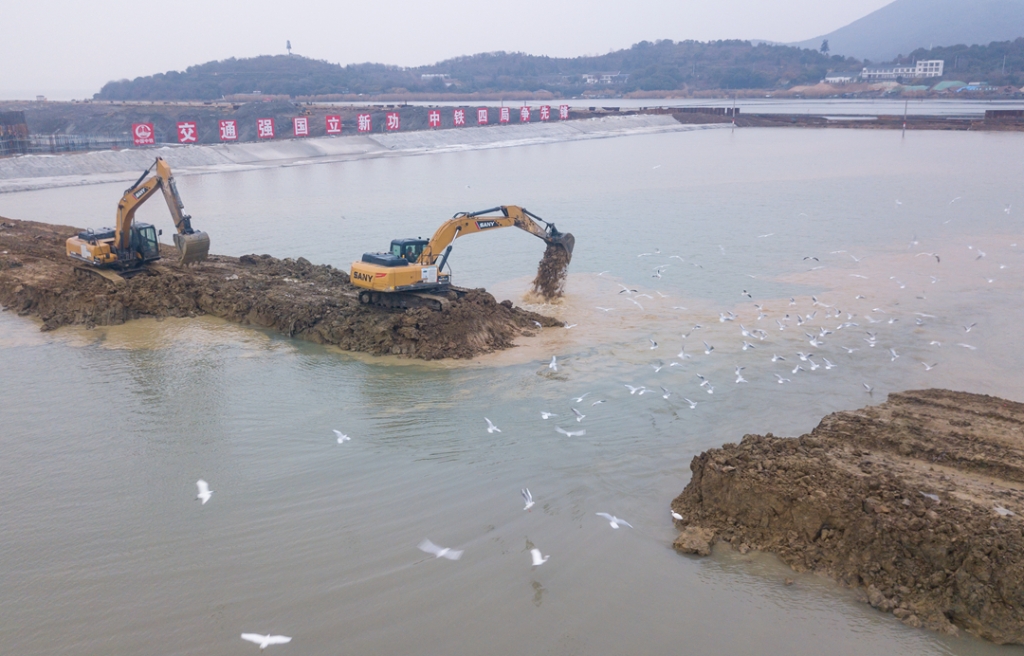 2019年12月23日，鳥群從陸島轉(zhuǎn)換圍堰回水施工現(xiàn)場飛過。